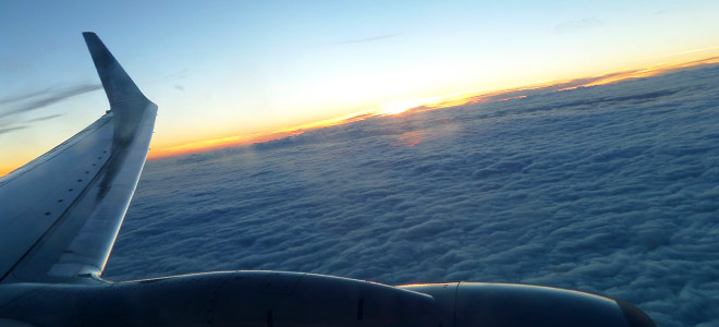 Airplane View Above The Clouds at Sunset